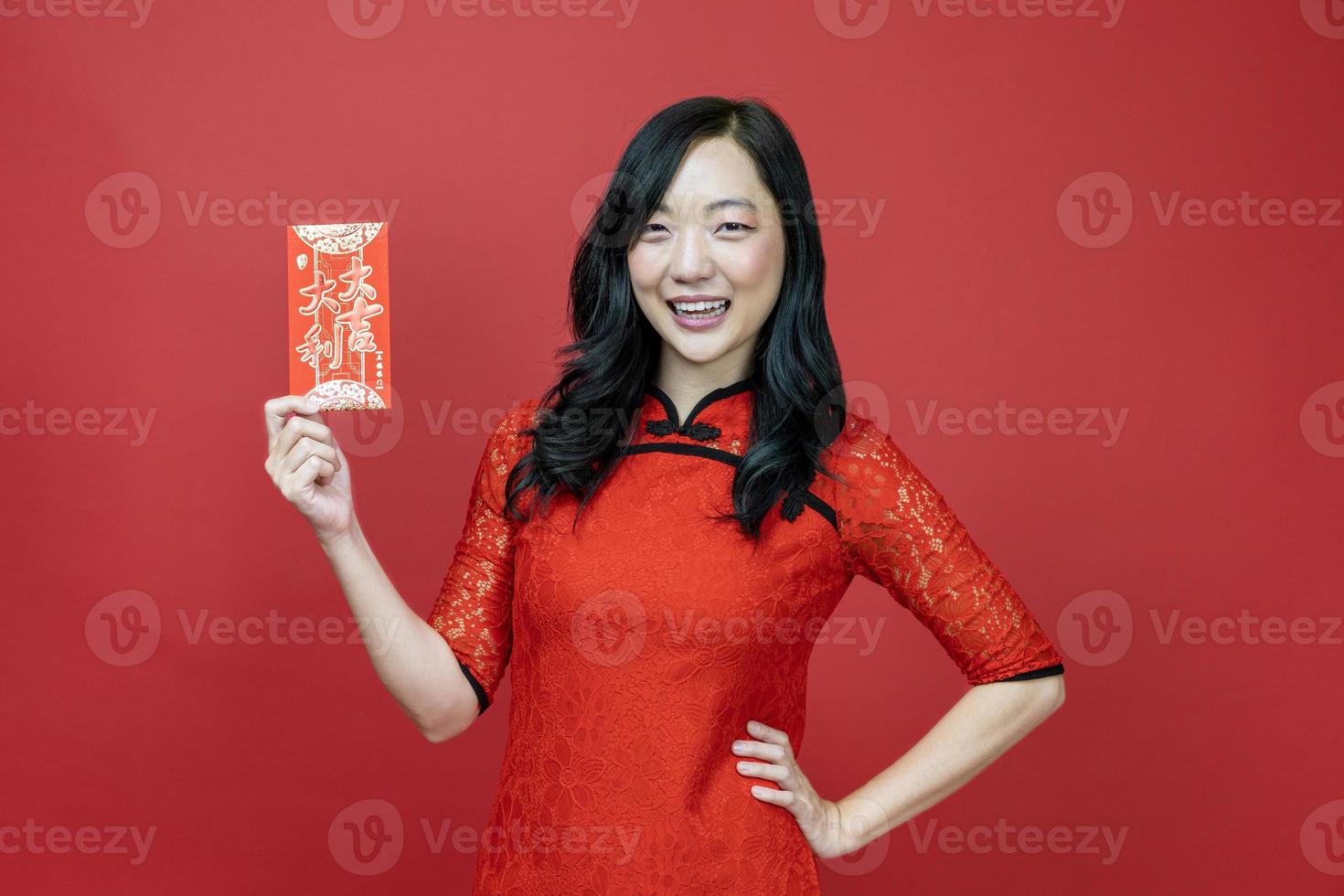 Asian woman holding red money fortune envelope blessing Chinese word which means may you have great luck and great profit isolated on red background for Chinese New Year celebration concept photo