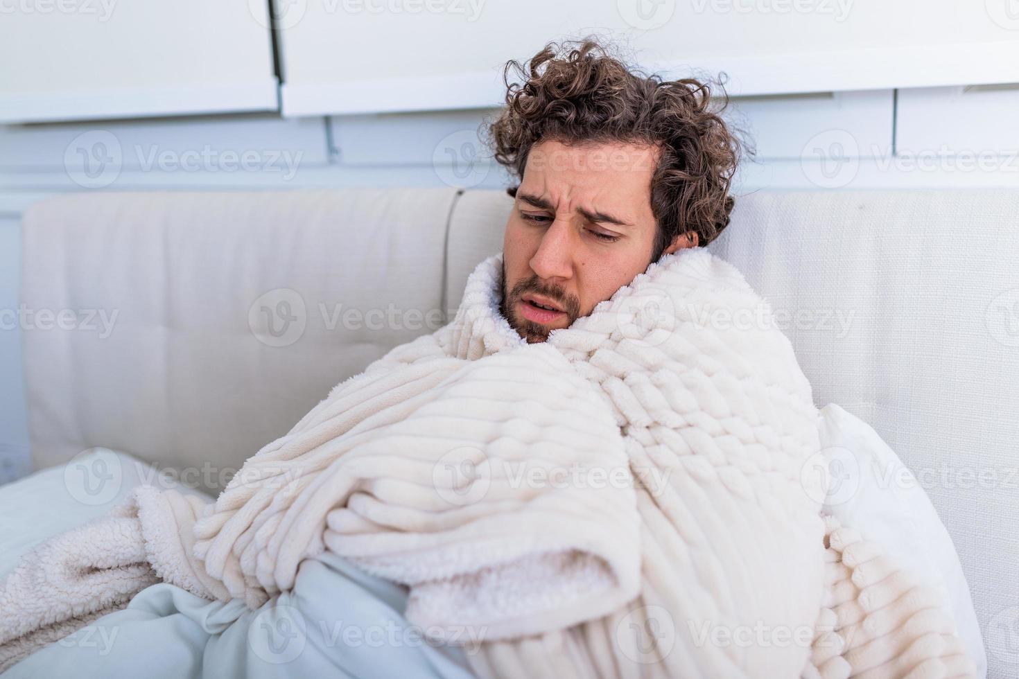 Sick day at home. Handsome Man has fever and common cold. Cough. Closeup Of Young Man Caught Cold Or Flu Illness. Portrait Of Unhealthy man Feeling Pain In Throat. photo