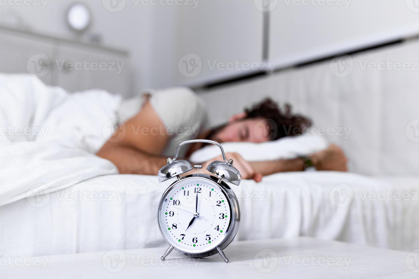Sleep longer. Health care concept. Stages of sleep. Man awake unhappy with alarm ringing. Although you sleep you may wake up feeling like did not sleep at all. photo