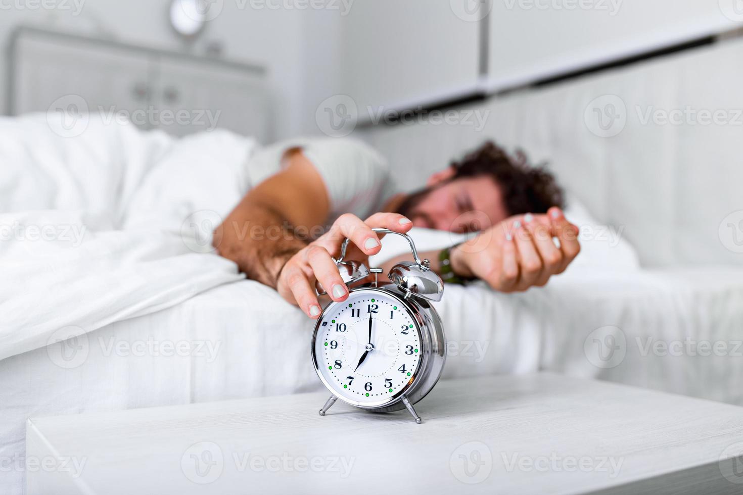 Sleep longer. Health care concept. Stages of sleep. Man awake unhappy with alarm ringing. Although you sleep you may wake up feeling like did not sleep at all. photo