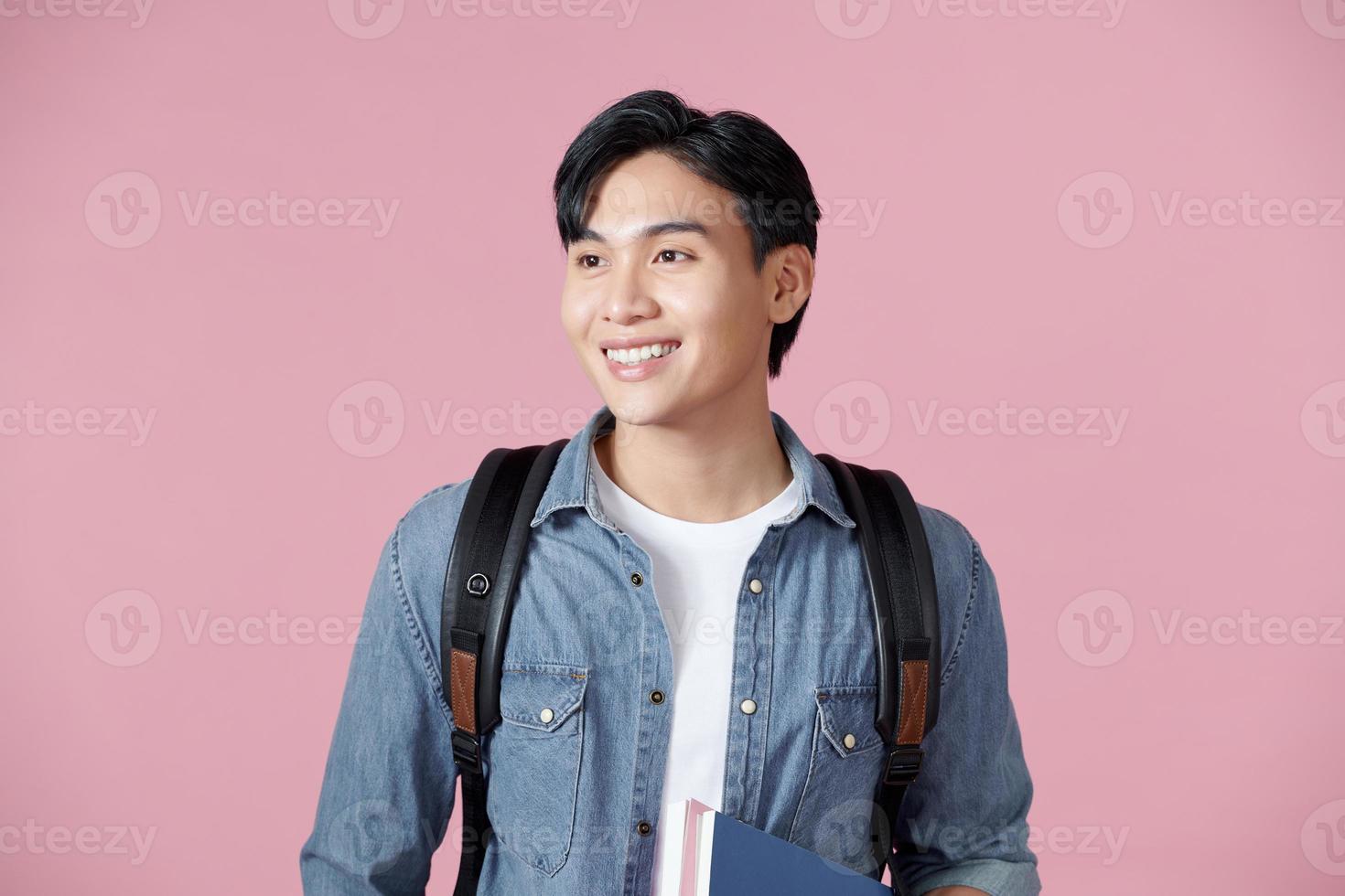 happy smiling student standing with backpack and folders over pink background photo