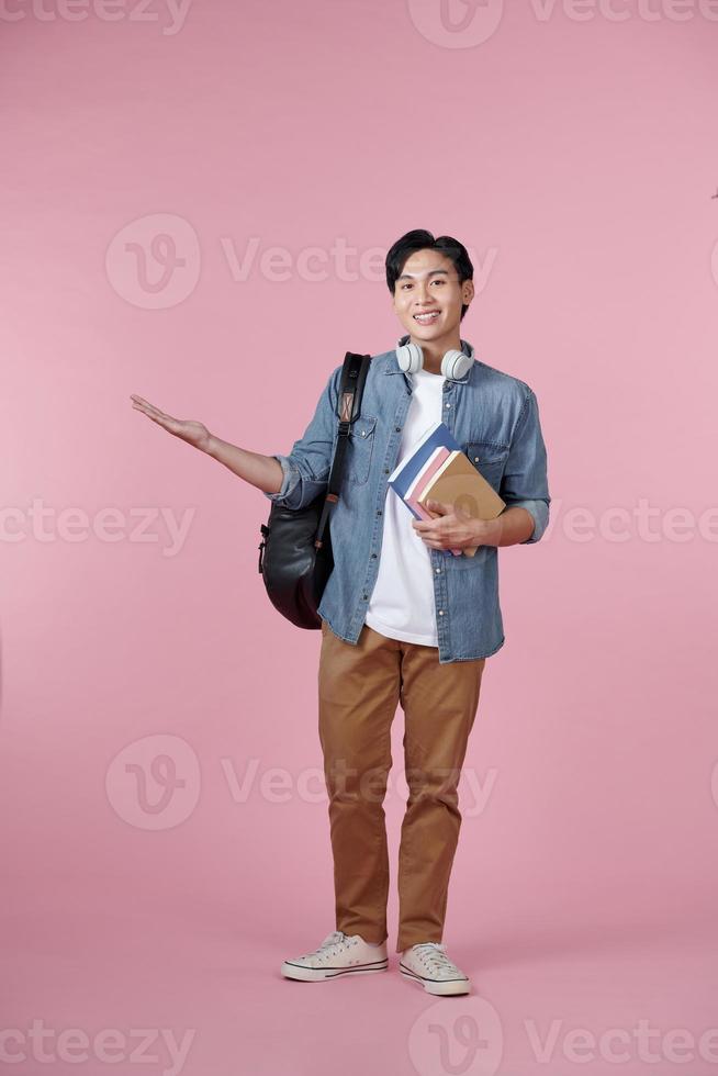 Young student man isolated on pink background extending hands to the side for inviting to come photo