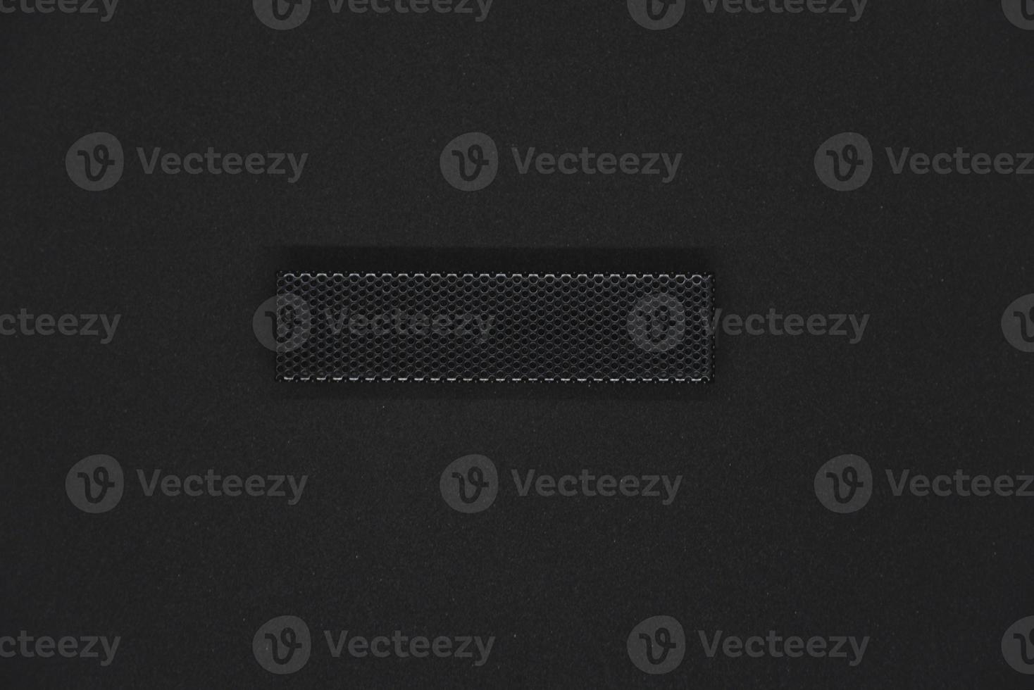 The iron panel from the computer. Iron black mesh panel. Metal rectangular panel on a black background. Beautiful iron rectangular black shape. photo