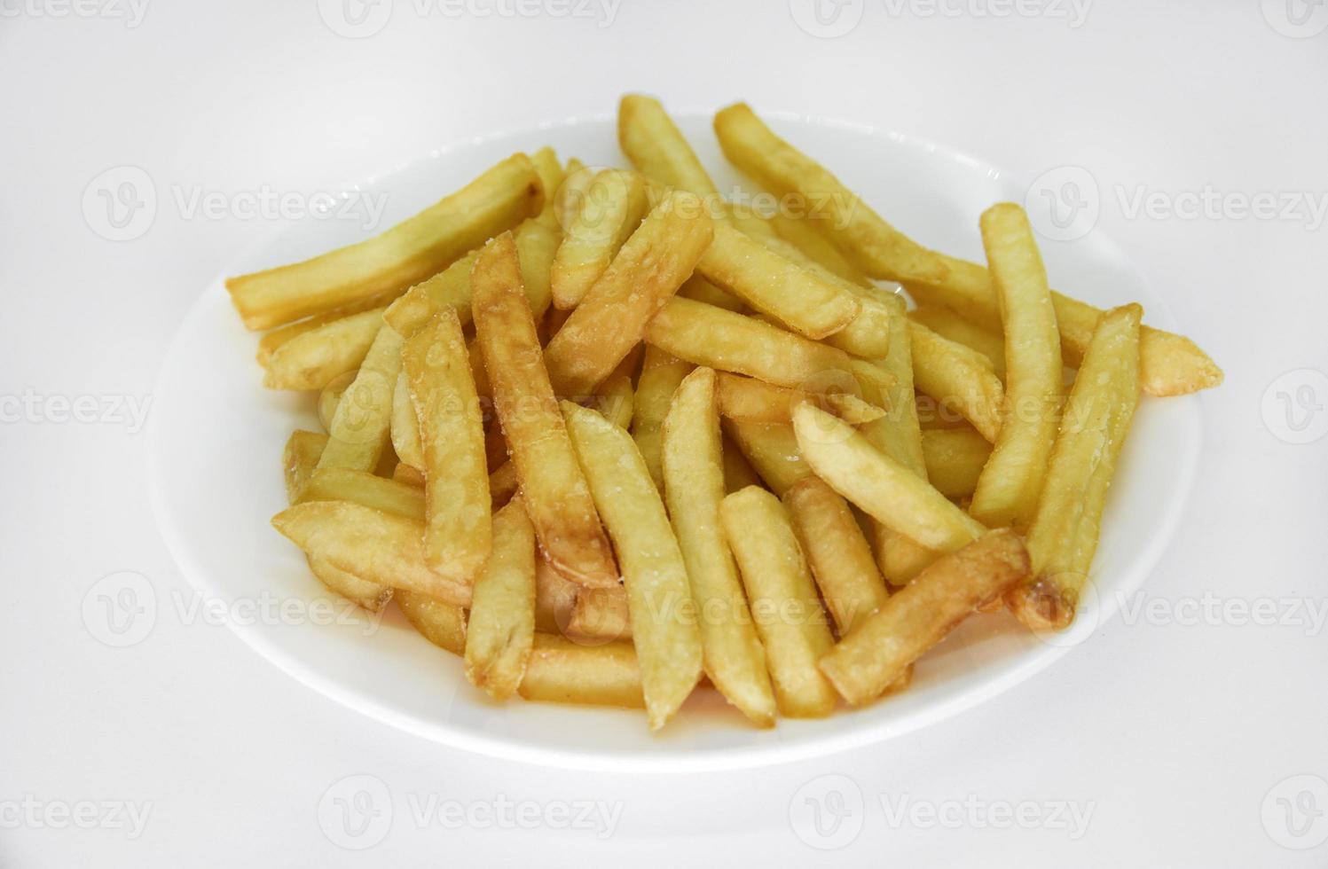 Yellow delicious French fries in white dishes. Fast food on a plate. Fried potatoes. Toasted potato slices on a white background. photo