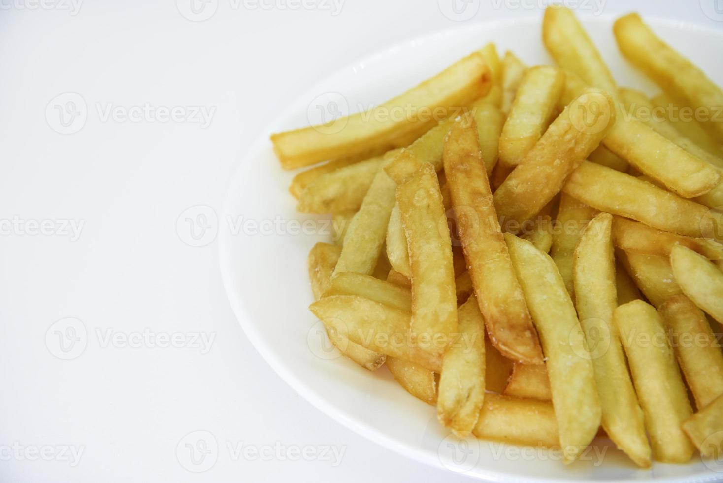 Yellow delicious French fries in white dishes. Fast food on a plate. Fried potatoes. Toasted potato slices on a white background. photo