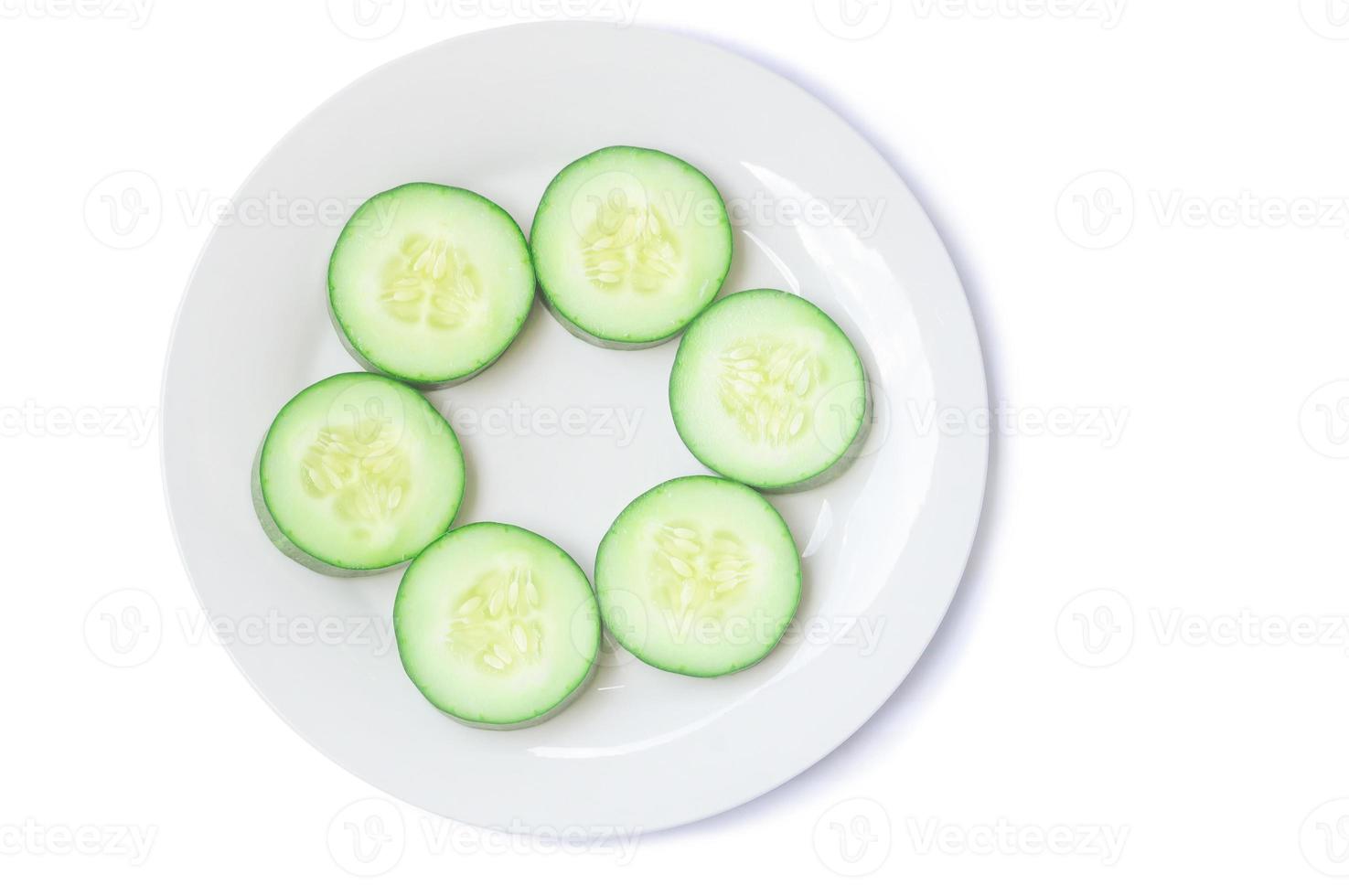 Top view of fresh cucumber slices on white plate or dish isolated on white background with clipping path photo