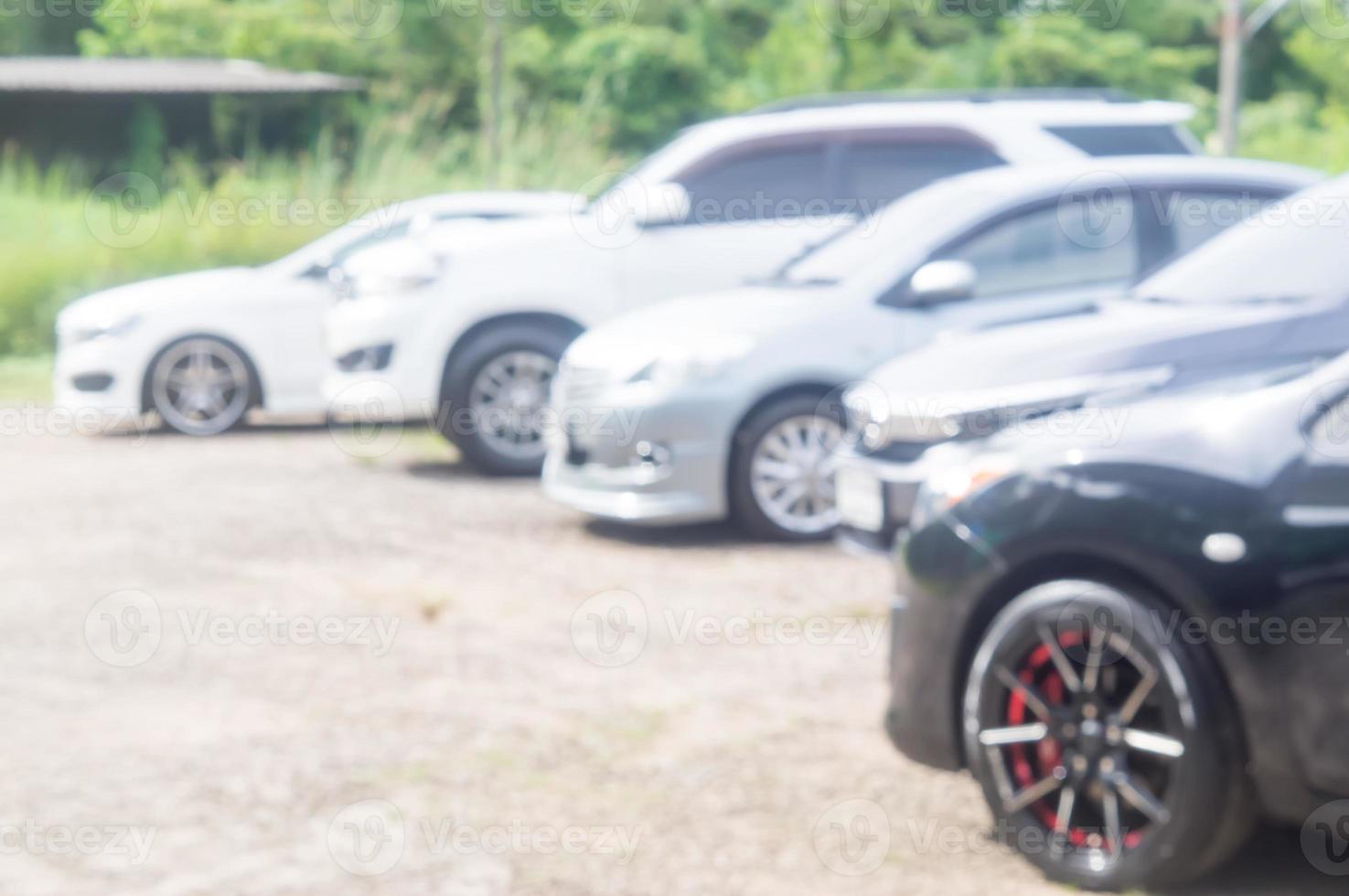 Cars parking at parking lot with no roof in open area in front of office, university, school or hospital on sunny day, Blurred and close photo