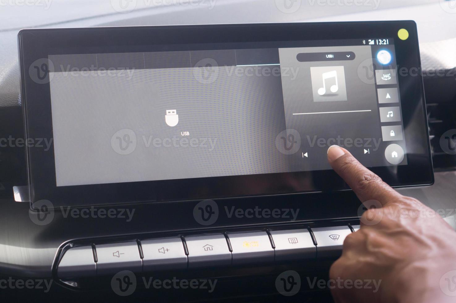 Close up photo, driiver's forefinger touching flat screen player to turn on music while driving super modern car, Concept of using high technology accessories in modern car in vintage color tone. photo