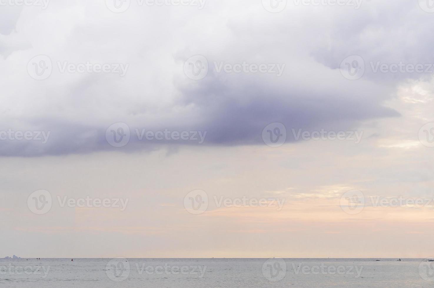 luz naranja del cielo con nubes oscuras en el mar por la tarde o por la mañana de vacaciones, el paisaje tomado en el mar de andaman en el sur de tailandia foto