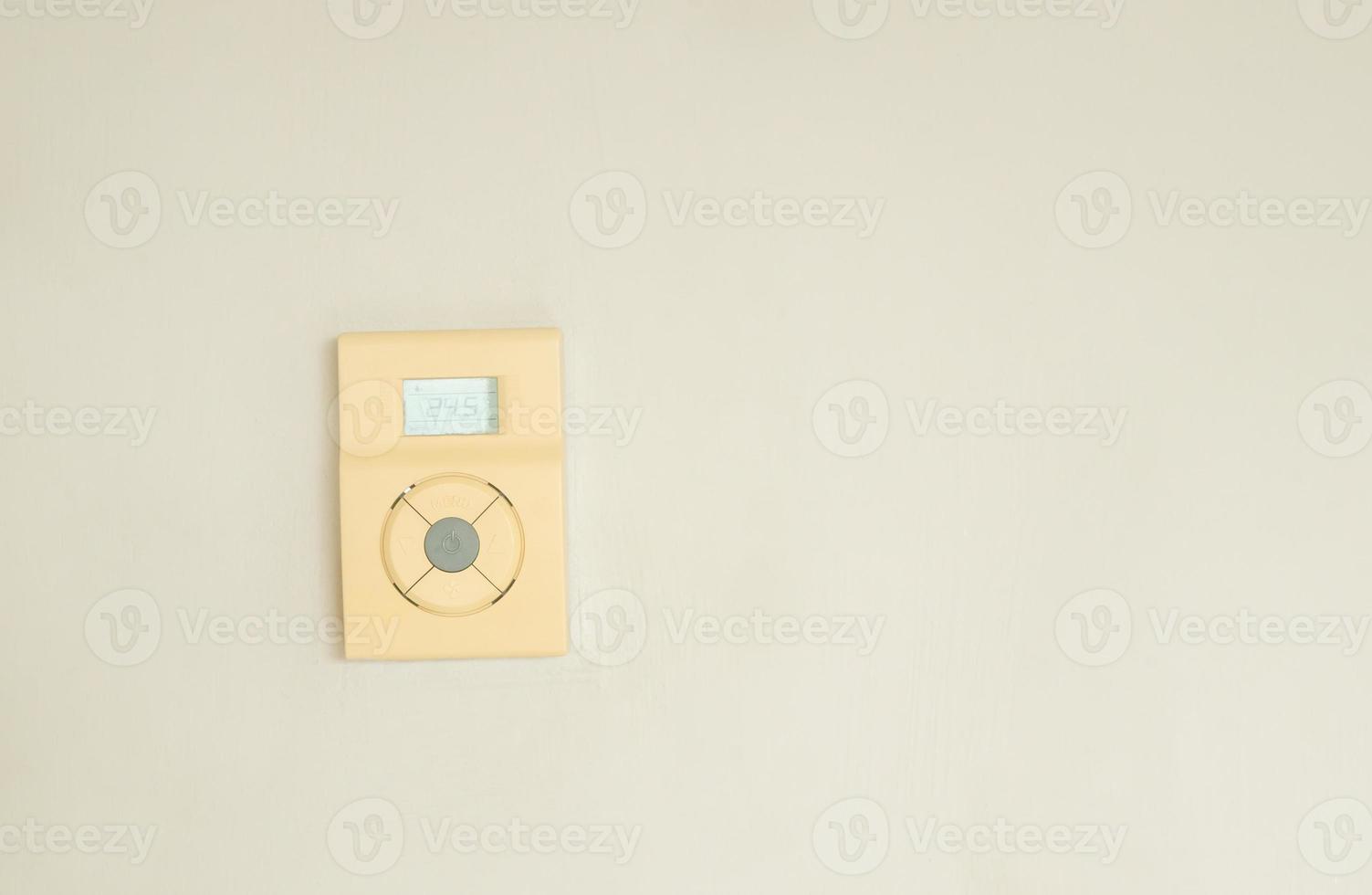 Digital air conditioner controller installed on room wall in hotel on white or grey background with copy space photo