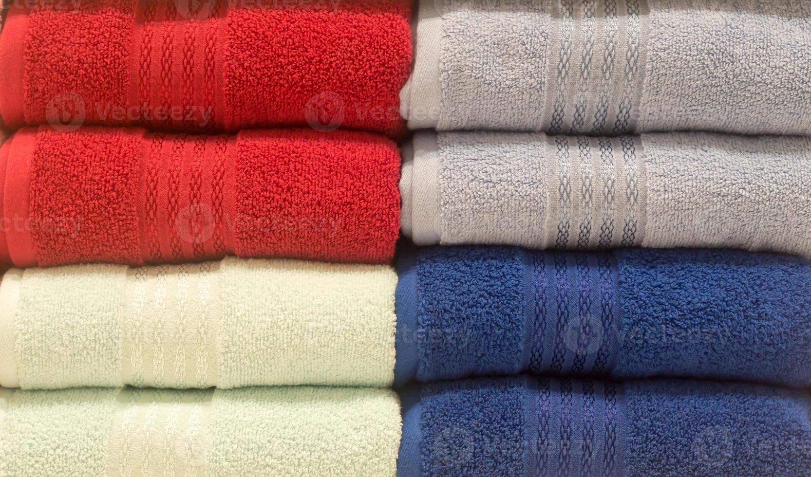 Beautiful colorful bath towels tidily folded on shelves in department store used as pattern background photo