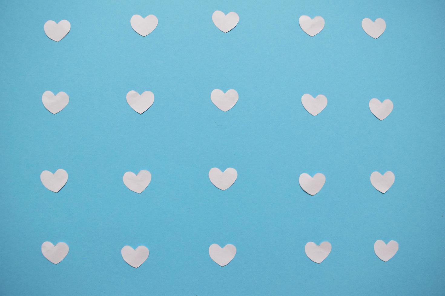 white hearts on a blue background. Valentine's day hearts pattern. Valentines day card with white hearts photo