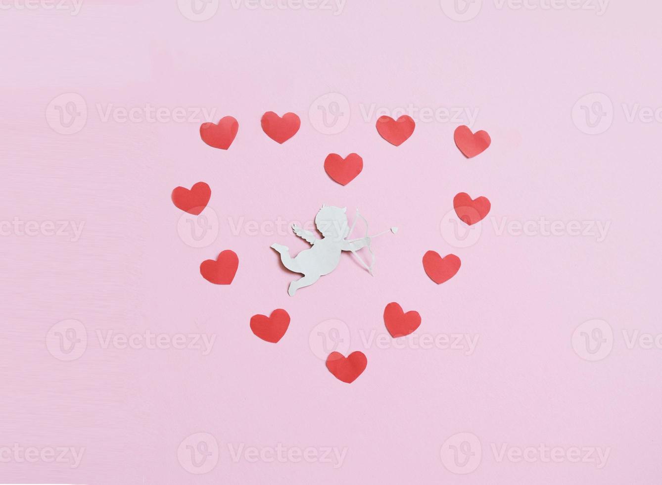 valentines day consept. red color hearts and cupid aiming in heart on pink background. valentines day cards. photo