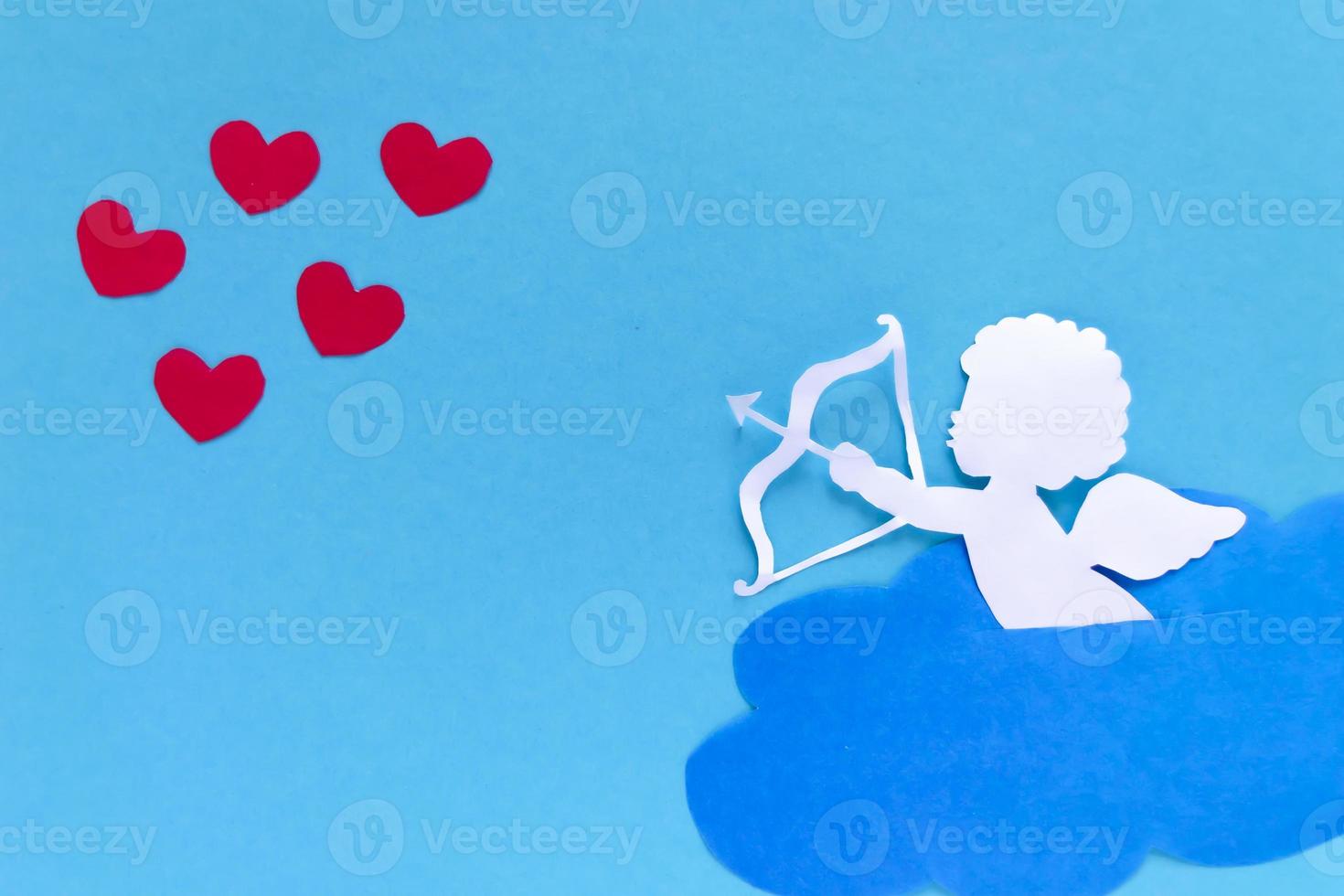 valentines day consept. red hearts and cupid aiming in heart on blue background. creative valentine's day card. photo