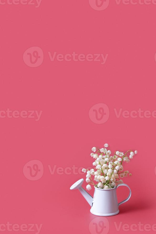tarjeta de felicitación vertical en blanco para el día de la madre con ramo de flores de lirios del valle en una lata de agua decorativa. foto