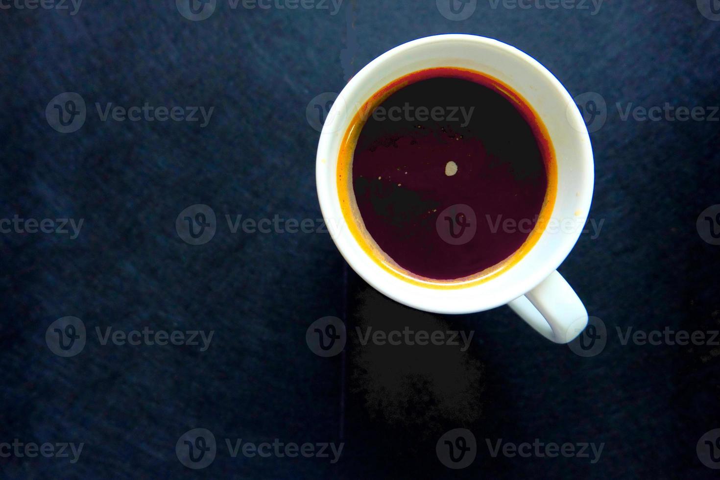 Cup of black coffee on black table photo