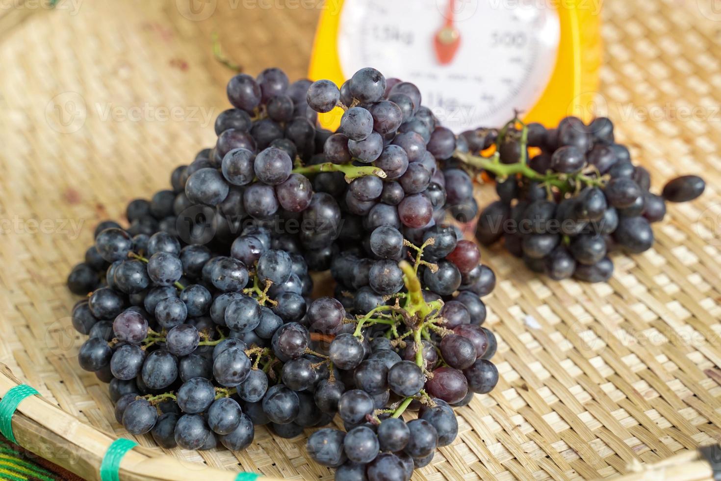 A bunch of seedless grapes in bamboo baskets that farmers sell at the market. soft and selective focus. photo