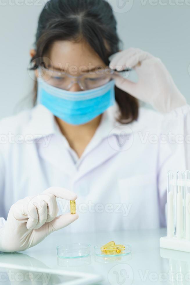 Scientist holding Omega 3 capsule in labcoat photo