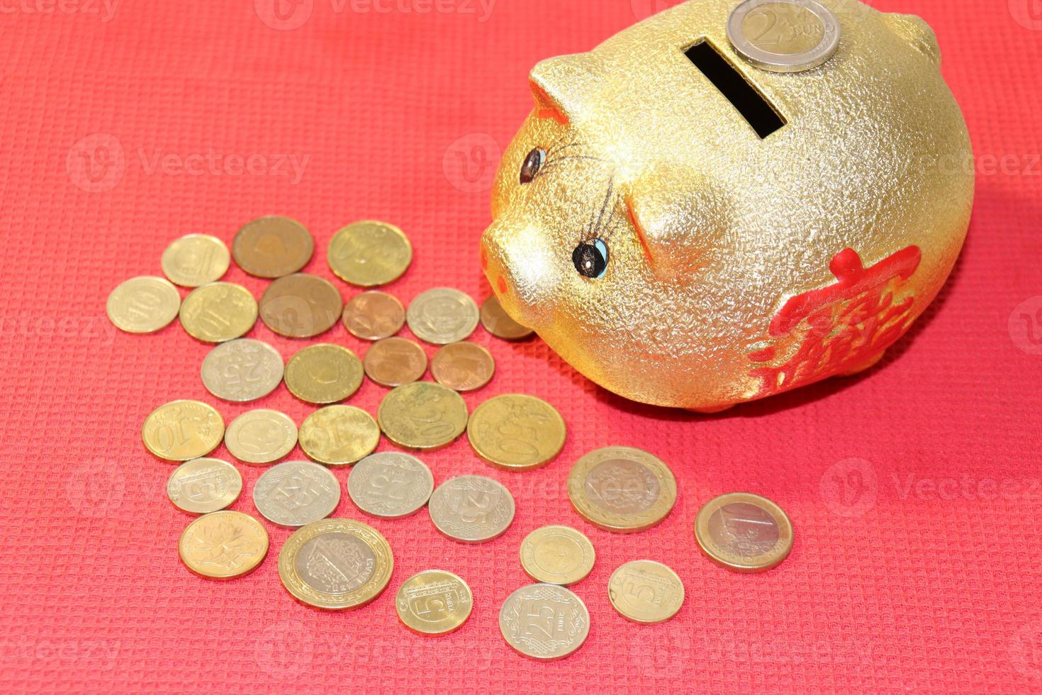 golden piggy bank and coins on a red background photo