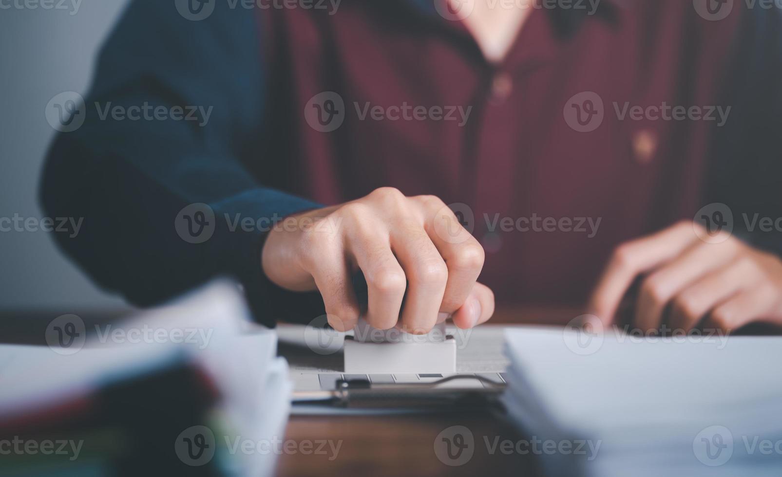 Businessman validates and manages business documents and agreements, signing a business contract approval of contract documents confirmation or warranty certificate,approval stamp photo