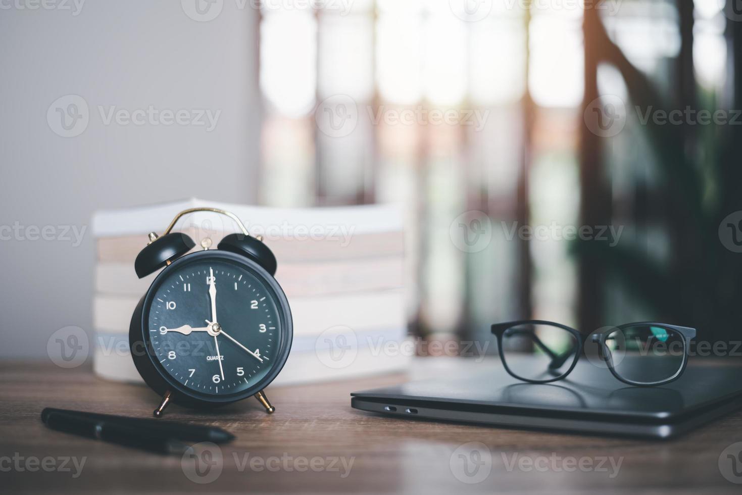 Alarm clock, laptop, books, all on the table,online training,distance learning,self learning,e-learning ,Educational or training courses, seminars,searching for information manually photo