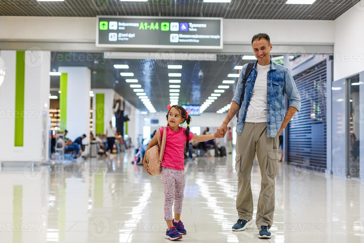 father and little daughter walking in the airport, family travel photo