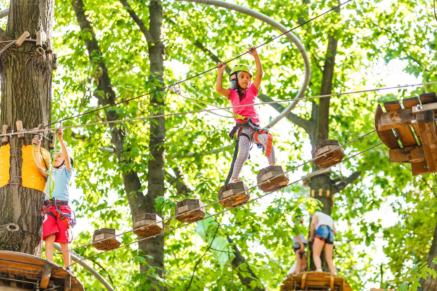 happy little children in a rope park on the wood background photo