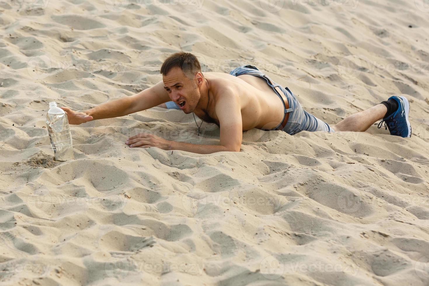 Thirsty man in the desert reaches for a bottle of water photo