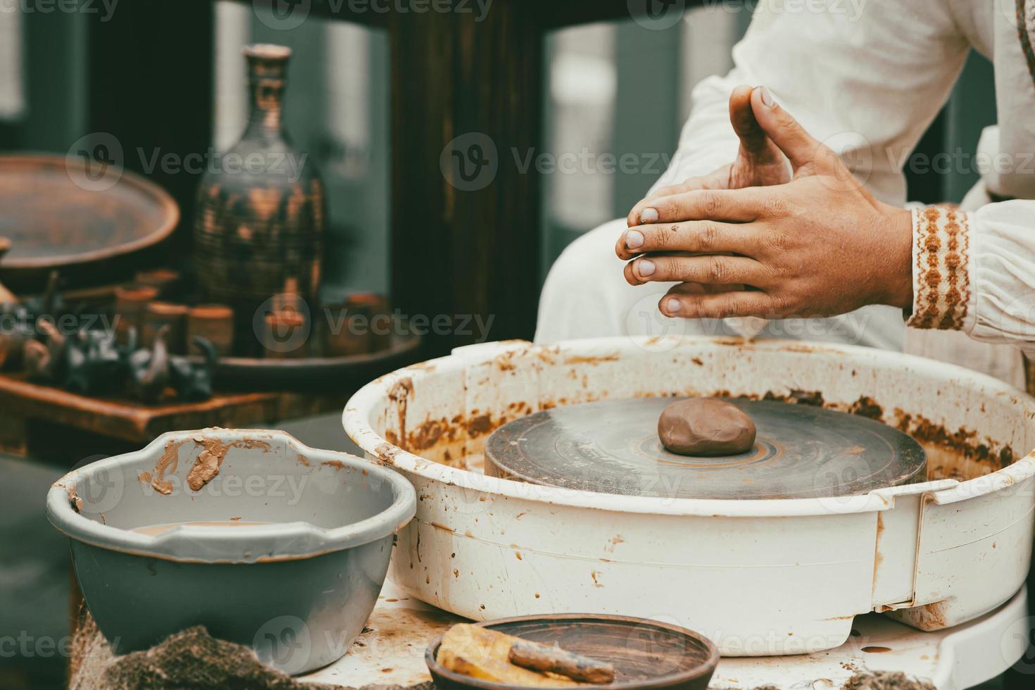 Piece of natural terracotta clay in hands. Wet clay material for sculpture or modeling. photo