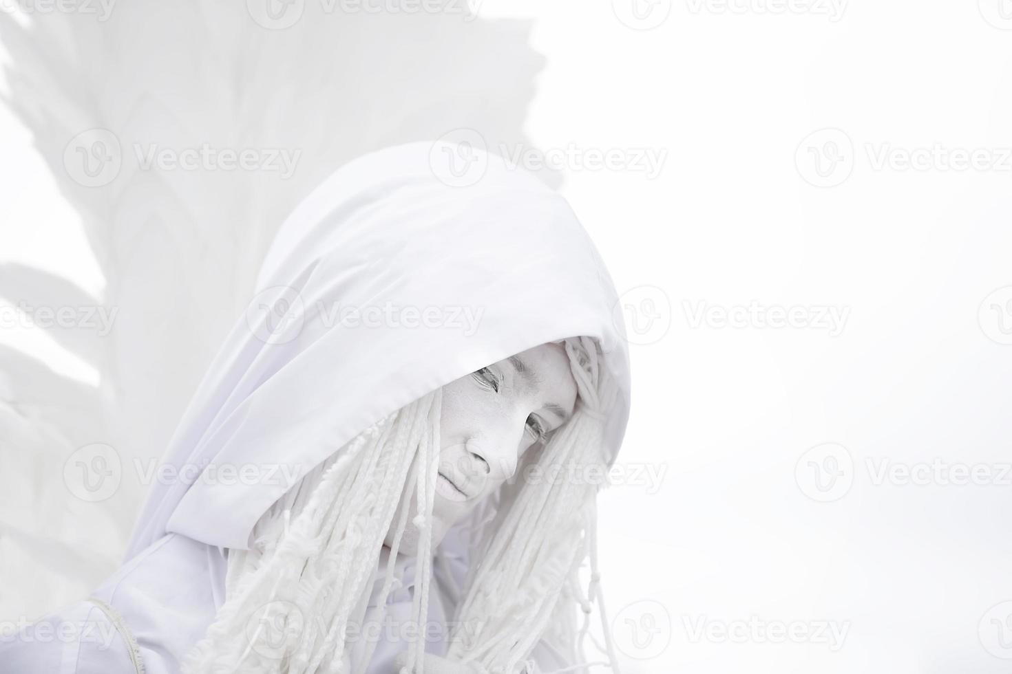 A man in a white angel costume with wings close-up.Gothic white angel. photo