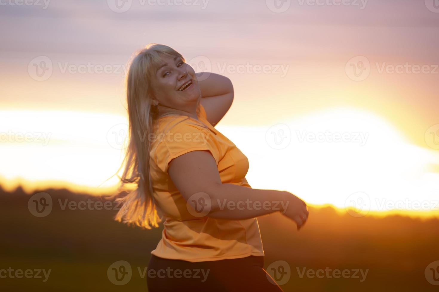 Portrait of a European middle-aged woman in a tracksuit, posing for the camera, relaxing. excited overweight woman in trendy tracksuit resting after exercising. photo