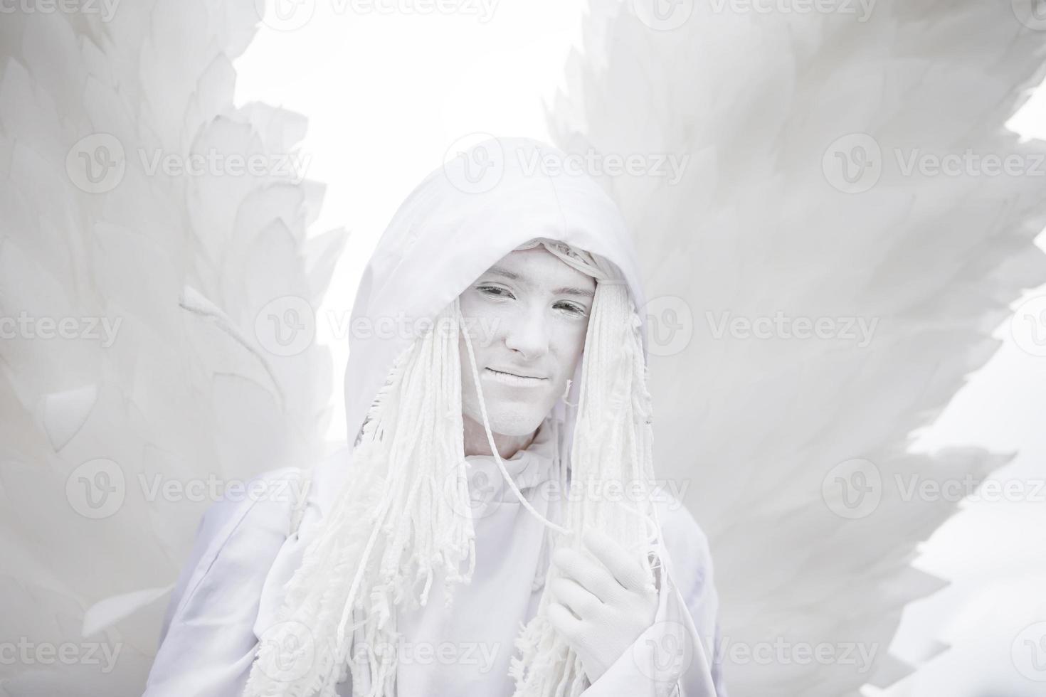 un hombre en un traje de ángel blanco con alas close-up.ángel blanco gótico. foto
