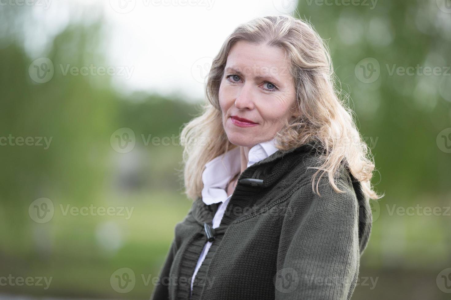 Portrait of a beautiful elderly blonde woman of European appearance. Fifty-year-old woman close-up on a natural background photo