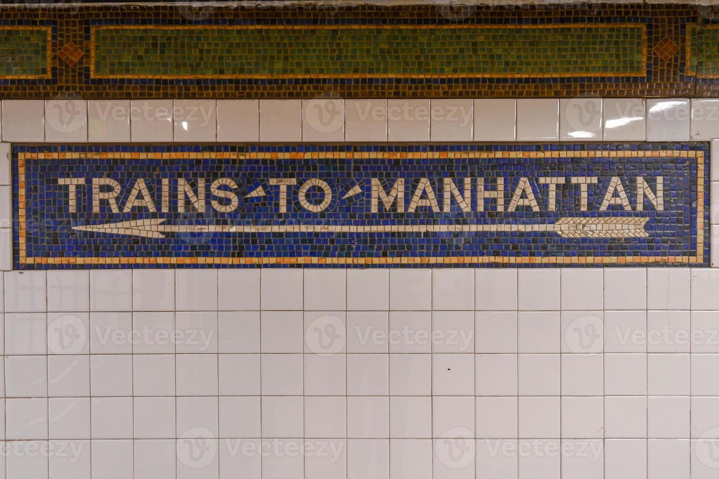 Trains to Manhattan mosaic arrow sign in the  NYC Subway. photo