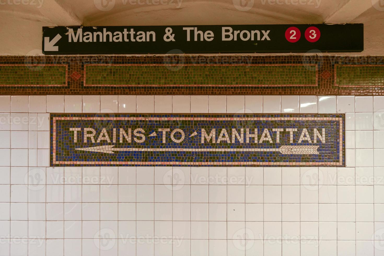 Trains to Manhattan mosaic arrow sign in the  NYC Subway. photo