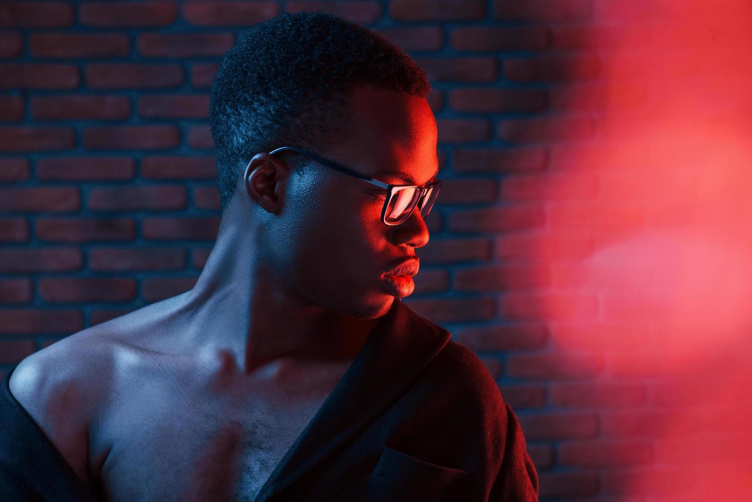 Light blinks. Futuristic neon. Young african american man in the studio photo