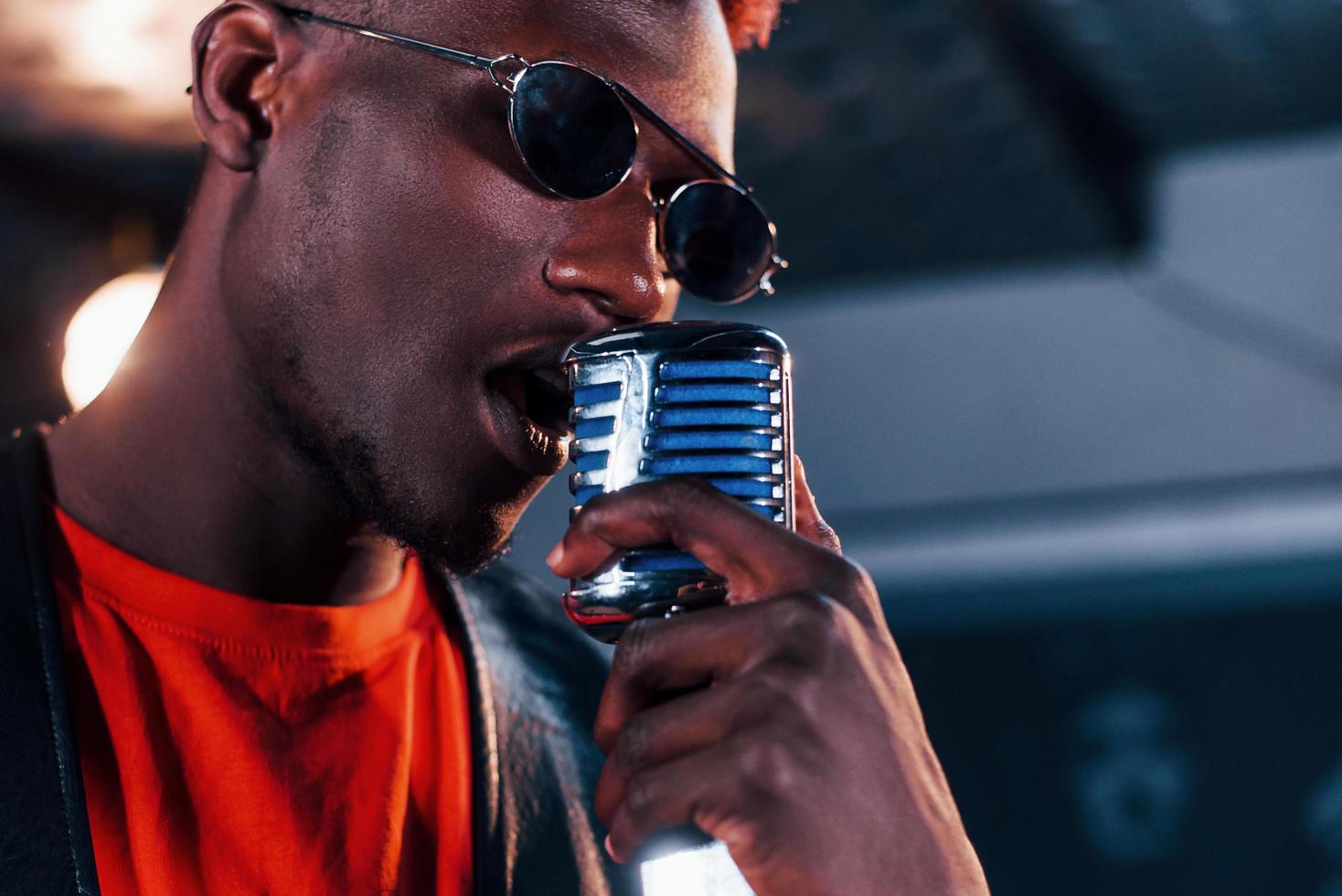 Having vocal practice. Young african american performer rehearsing in a recording studio photo