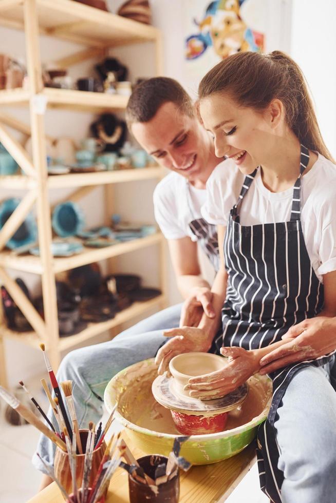 With her boyfriend or husband. Young female ceramist have a works indoors with handmade clay product. Conception of pottery photo