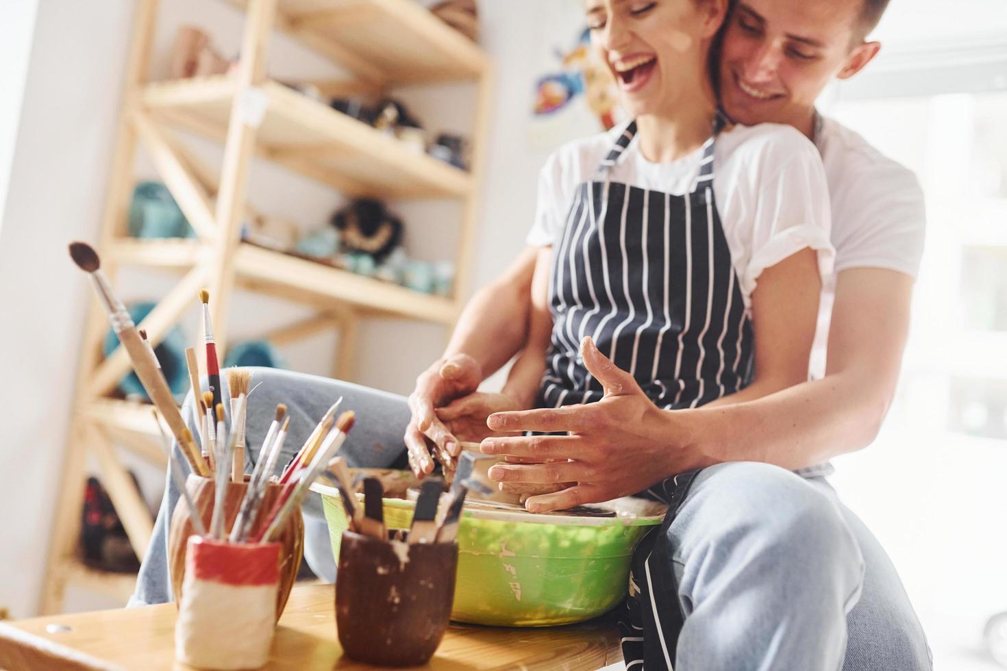 With her boyfriend or husband. Young female ceramist have a works indoors with handmade clay product. Conception of pottery photo