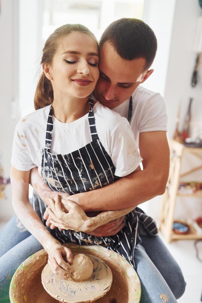 con su novio o esposo. joven ceramista en interiores con productos de arcilla hechos a mano. concepción de la cerámica foto