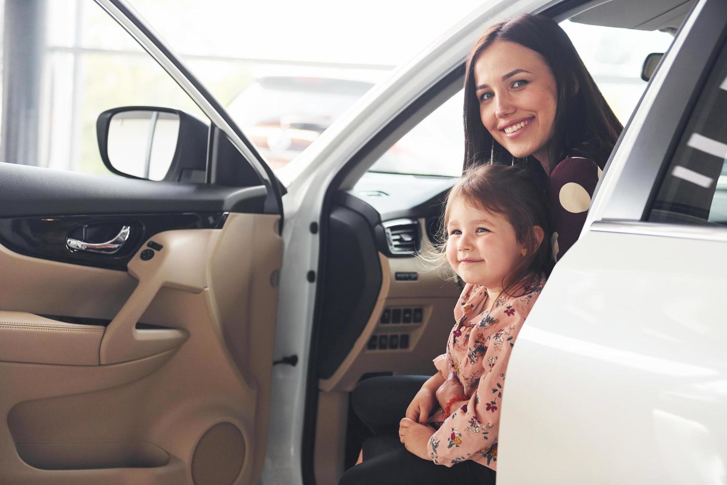 Mother with her daughter inside of modern automobile together photo