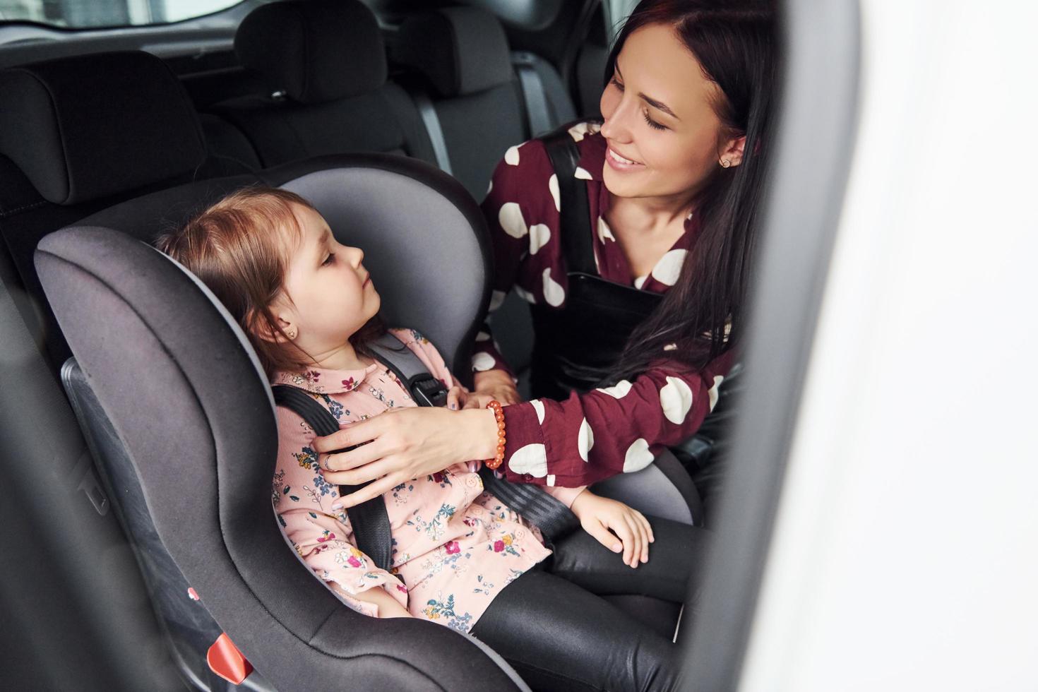 Mother with her daughter inside of modern automobile together photo