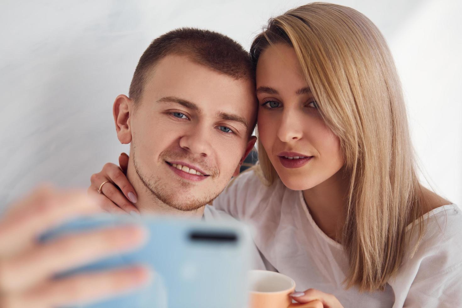 Man holding phone and making selfie of himself and his girlfriend photo