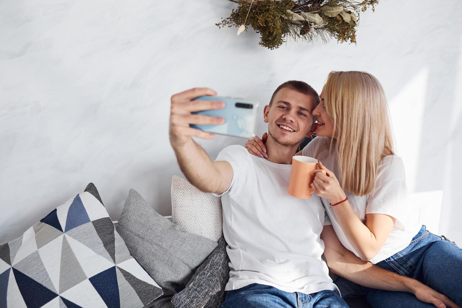 hombre sosteniendo el teléfono y haciéndose selfie de sí mismo y su novia foto