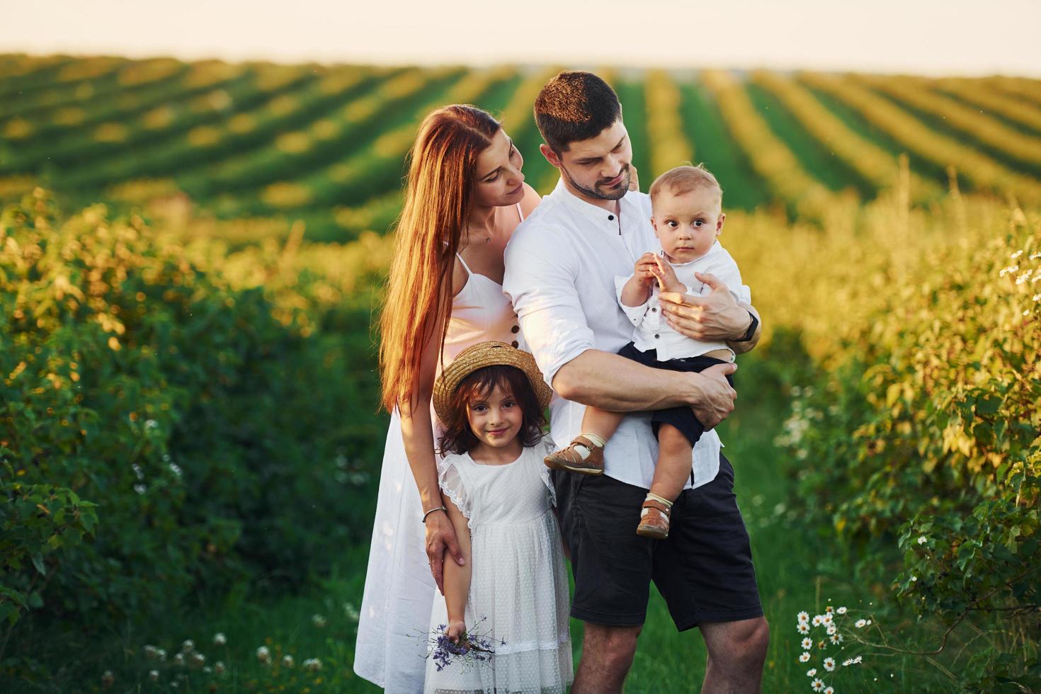 padre, madre con hija e hijo pasando tiempo libre al aire libre en los días soleados de verano foto