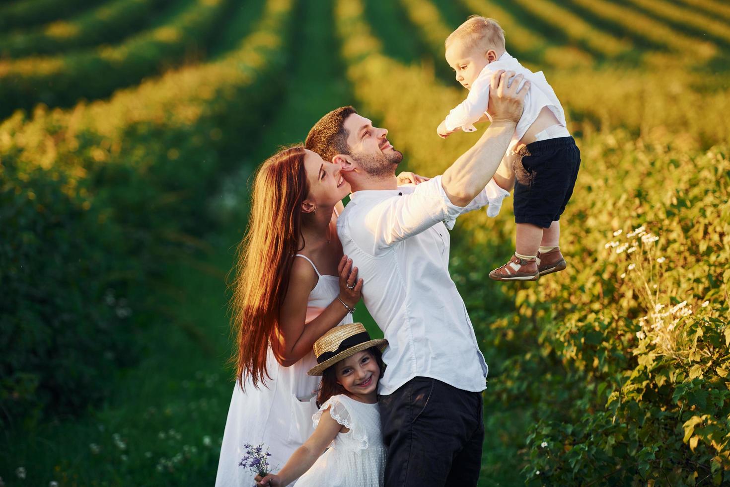 padre, madre con hija e hijo pasando tiempo libre al aire libre en los días soleados de verano foto