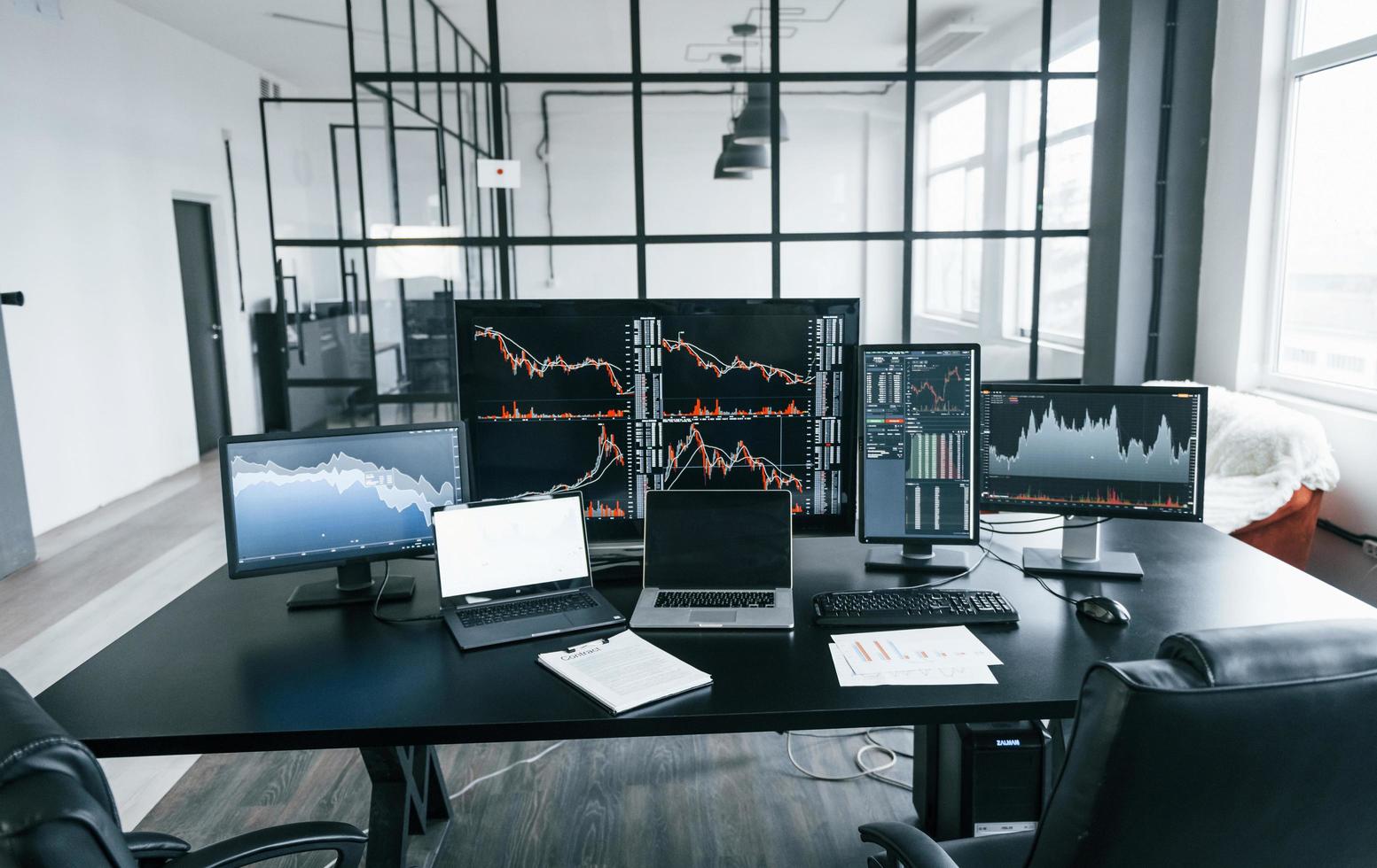 Interior of modern office with many of computer screens with stock information. No people photo