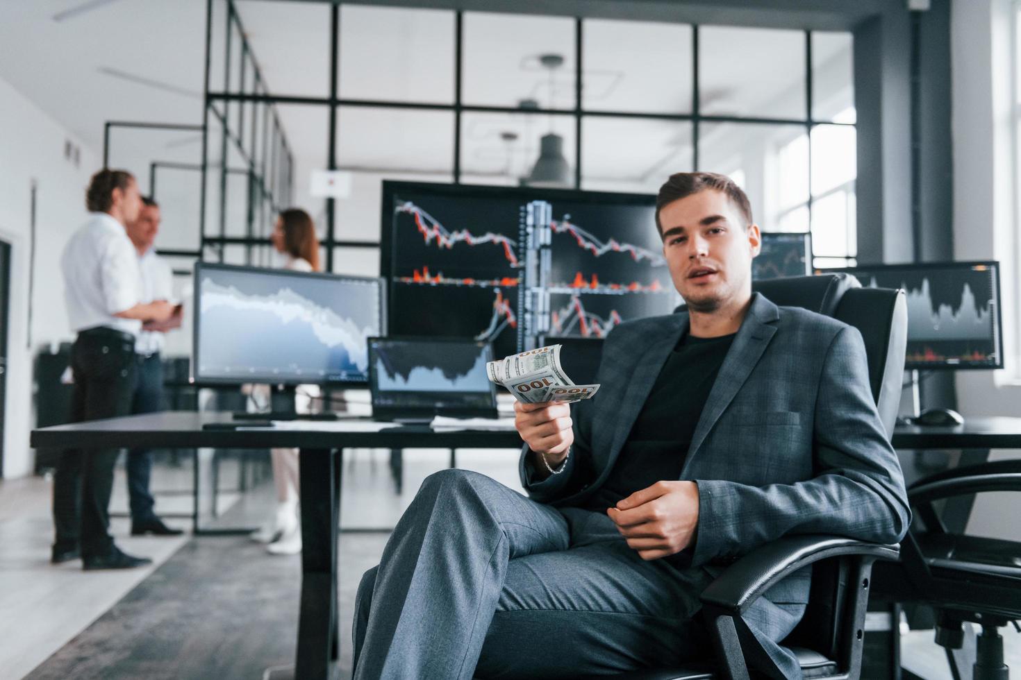 Ordinary office day. Team of stockbrokers works in indoors with many display screens photo