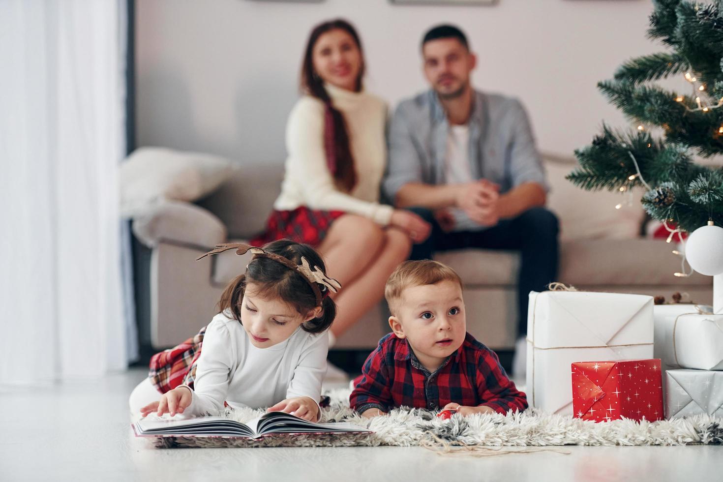 Sister and brother have fun. Beautiful family celebrates New year and christmas indoors at home photo