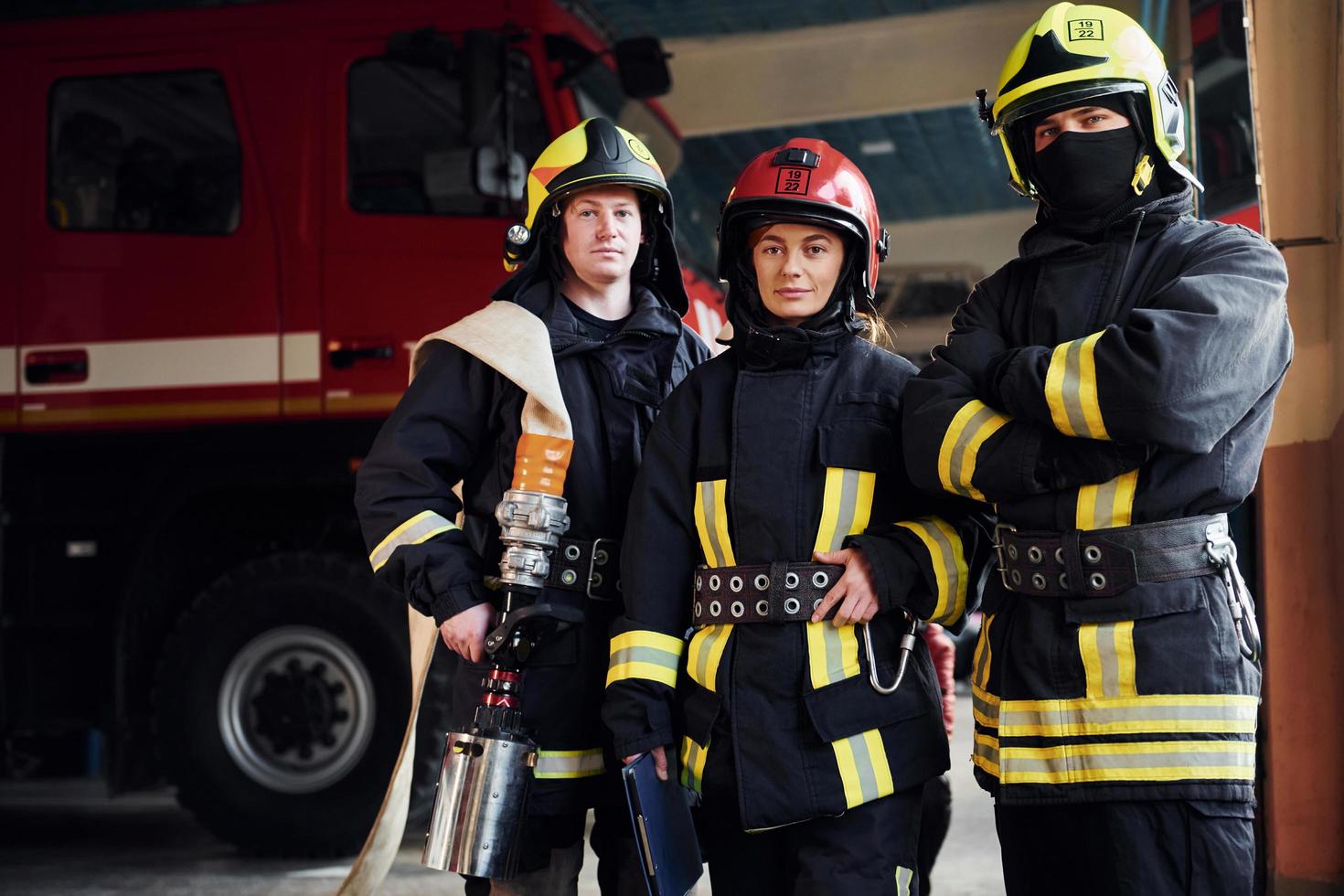 posando para una cámara. grupo de bomberos con uniforme protector que está en la estación foto